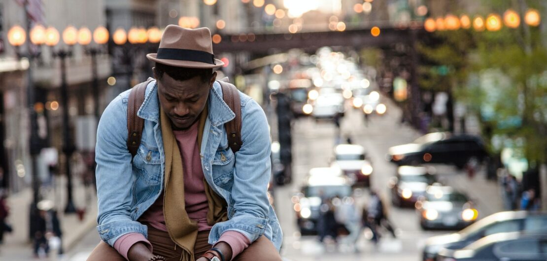 sad older man sitting on the street