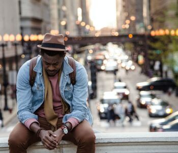 sad older man sitting on the street